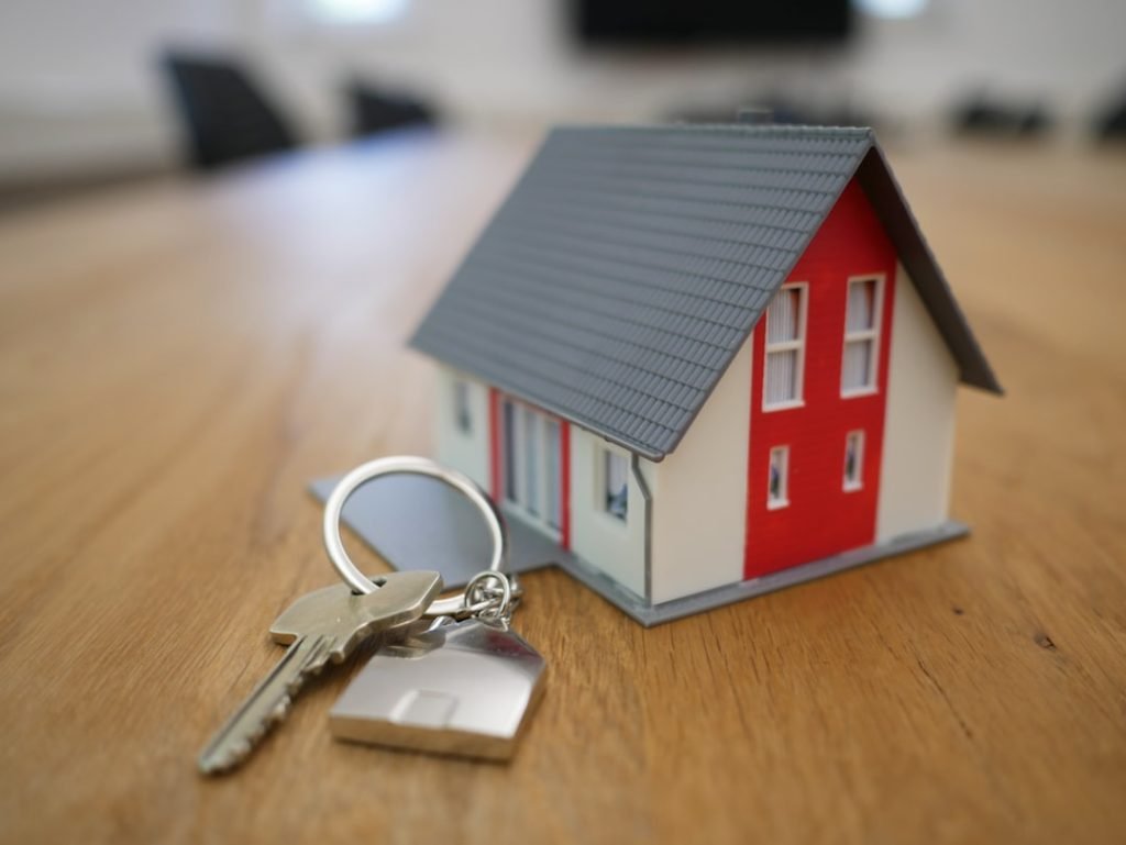 white-and-red-wooden-house-miniature-on-brown-table-rgj1j8sdeay